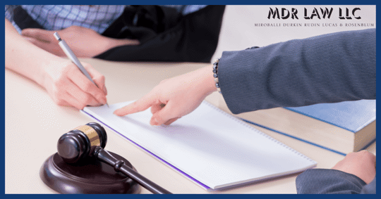 Woman Pointing at Document in Front of Man in Cast