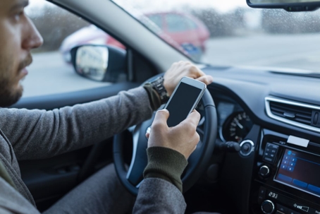 Driver with a cell phone in his hands