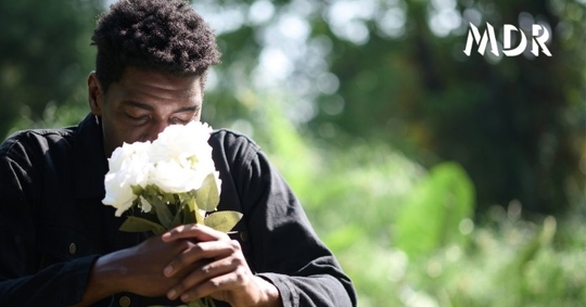 person holding flowers and grieving